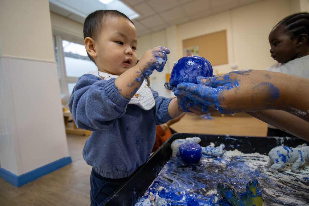 Playing with paint at LEYF Cumberland Road Nursery
