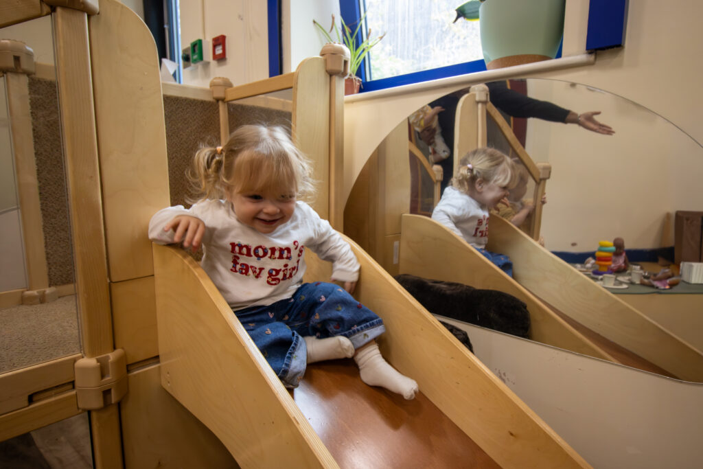Child going down the slide at LEYF Playhouse nursery