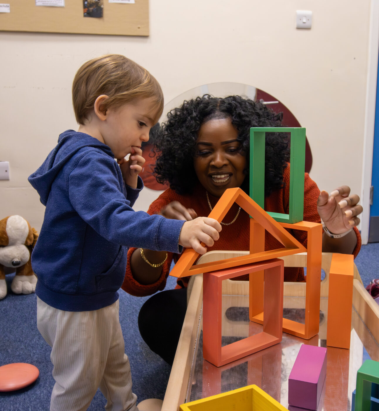 Teacher and child are playing with blocks